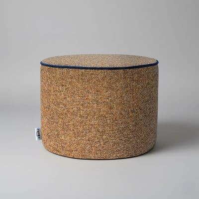 Footstool in ochre fabric on a grey background