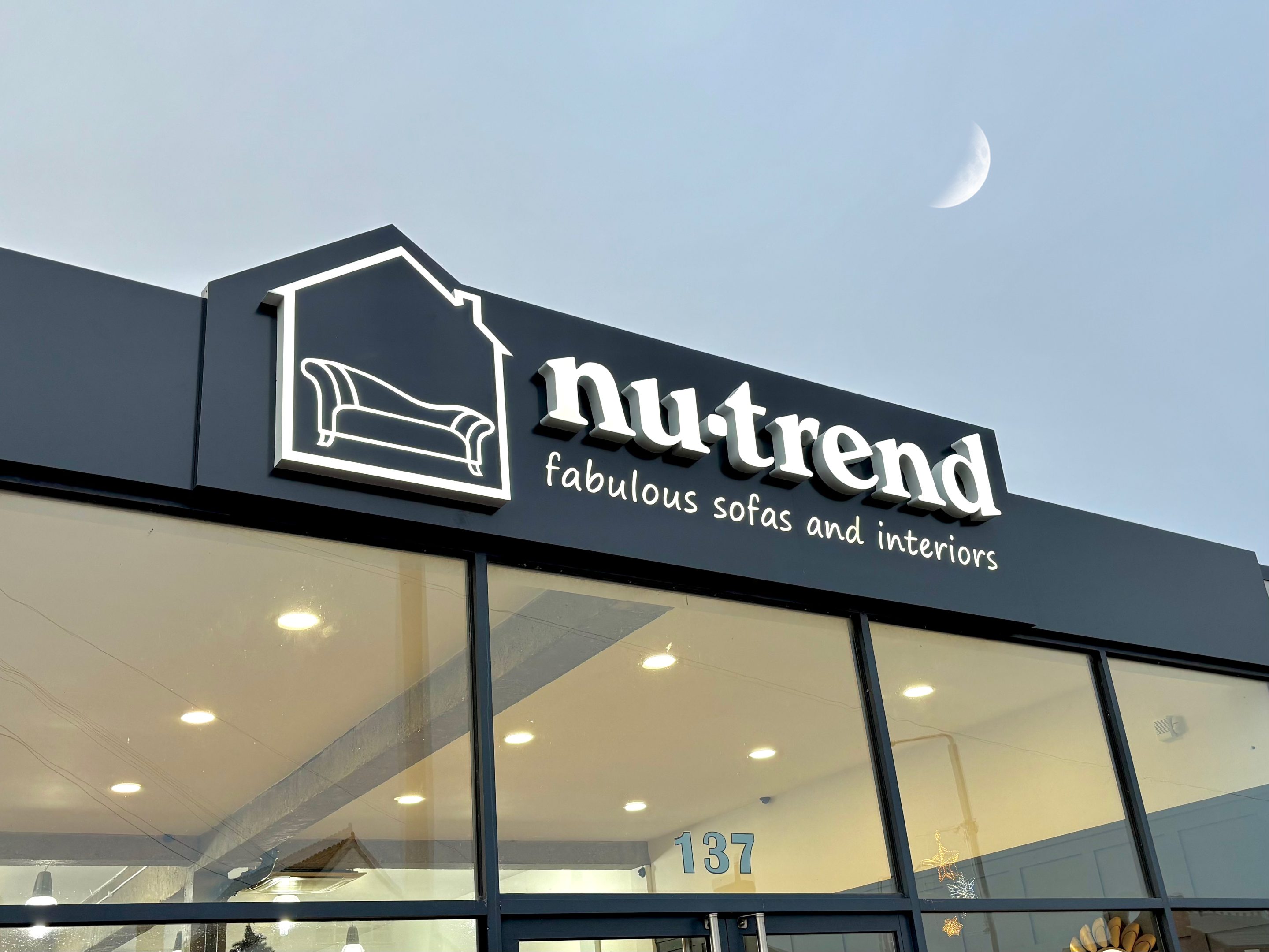nu trend exterior showroom sign, with the moon in the distance 